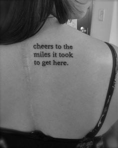 a woman with a tattoo on her back saying cheers to the miles it took to get here