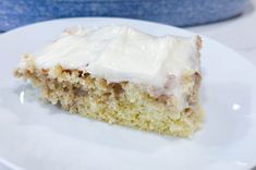 a piece of cake sitting on top of a white plate next to a blue bowl