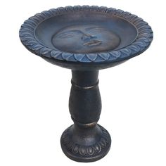 a decorative blue pedestal with a face on it's side and an ornate base