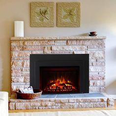 a living room with a fire place and two pictures on the wall above it,