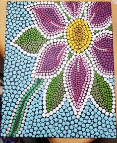 a painting made out of bottle caps with flowers painted on it