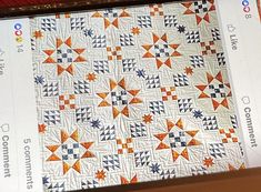 an orange and white quilt is on display