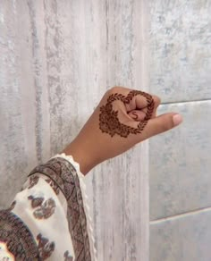 a woman's hand with a henna tattoo on her left wrist and finger