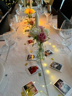 the table is set with flowers and pictures for guests to take photos on, along with candles