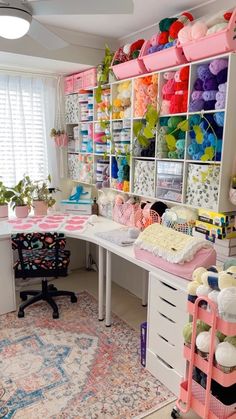 a room filled with lots of crafting supplies on top of a white desk next to a window