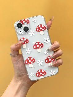 a woman holding up her phone case with mushrooms on it