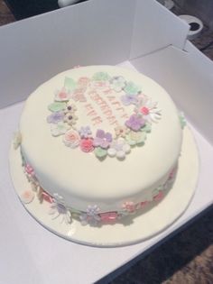 a white cake with flowers on it in a box