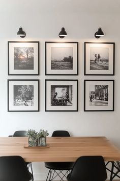 black and white photographs hang on the wall above a dining room table with four chairs