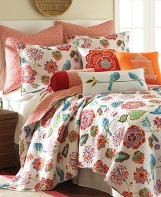 an orange and white comforter with colorful flowers on the coverlet is in a bedroom