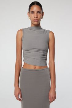 Effortlessly draped and versatile, the Selma tank is a must-have. With ruched detailing and a high neck, it's perfect for any occasion. Chic Asymmetrical Stretch Tank Top, Ruched Tank Top For Night Out, Flattering Fitted Sleeveless Top, Versatile Fitted Cami Tank Top, Fitted Seamless Tank Top For Layering, Seamless Fitted Tank Top For Layering, Chic Ruched Tank Top For Night Out, Chic Spring Tank Top, Chic Stretch Tank Top With Ruched Back