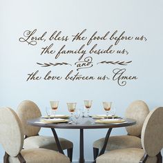 a dining room table with four chairs and a wall decal