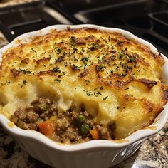 a casserole dish with meat and vegetables in it on a kitchen counter top