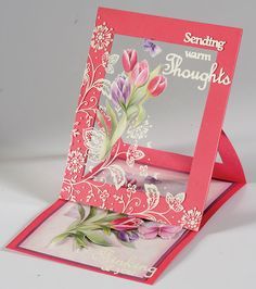 a greeting card with pink and white flowers on it, sitting in front of an easel