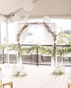 an outdoor wedding setup with white lanterns and greenery