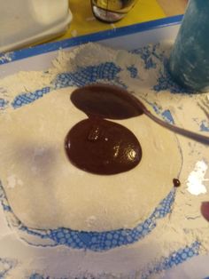 someone is spreading chocolate on top of dough