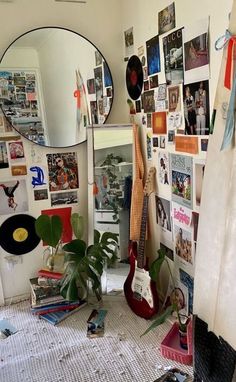 a room filled with lots of clutter and pictures on the wall next to a guitar