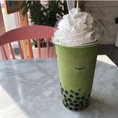 a green drink with whipped cream on top