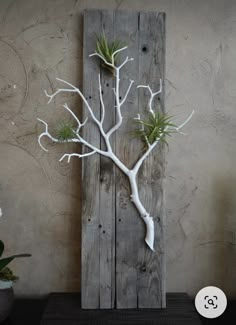 a tree made out of wood with white branches and green leaves on it's head