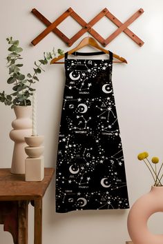 a black and white dress hanging on a wall next to a vase filled with flowers