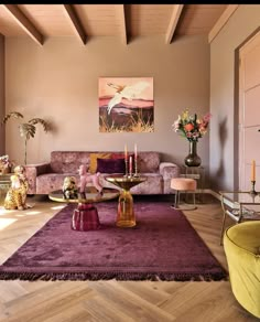 a living room filled with lots of furniture next to a painting on the wall above a coffee table