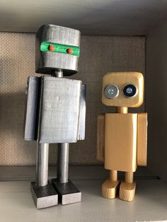 two wooden toy robots standing next to each other