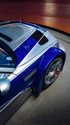 a blue and silver sports car parked on the street