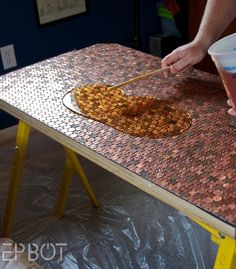 a person standing over a table with some food on it and chopsticks in their hand