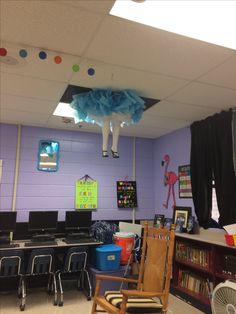 a classroom with purple walls and lots of bookshelves, desks, and chairs