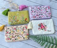 four embroidered purses with flowers and plants on them