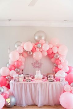 a table topped with pink and silver balloons