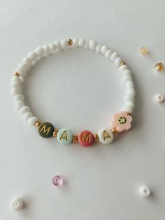 MAMA bracelet.  Perfect for stacking together with other bracelets or wearing separately.  Approximately 6.75 inches, could be made bigger or smaller, just send me a message.  Beads are 4mm, white and gold. 6mm Letter beads, colors will vary but we will try our best to have alternating colors. Mama Stack Bracelets, Mom Bead Bracelets, Mama Bracelet Beads, Beaded Bracelet Words, Mom Bracelet Ideas, Handmade White Beaded Bracelets For Mother's Day, Dainty White Name Bracelet For Everyday, White Adjustable Bracelets For Mother's Day, Spiritual White Heishi Beads Bracelets