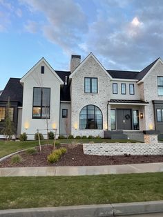 a large white brick house with lots of windows on the front and side of it