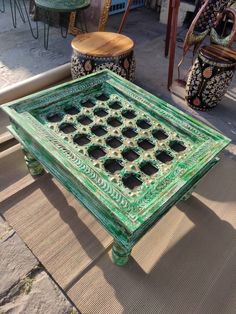 a green table sitting on top of a wooden floor