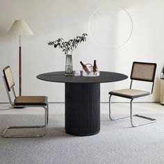 a table with two chairs and a vase filled with flowers sitting on top of it