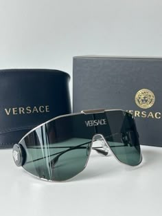 Brand new Versace VE2268 10003H Silver Medusa Shield Sunglasses. Oversized shield with medusa detailing on temples and silver metal logo across center lens. 1-14-115mm measurements. Dark Green lens. Comes with box, case, cloth, and all papers. Medusa Shield, Futuristic Sunglasses, Sunglasses Oversized, Green Lens, Sunglasses Logo, Stylish Glasses, Versace Accessories, Shield Sunglasses, Glamorous Wedding