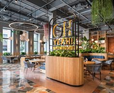 the interior of a restaurant with tables and chairs, plants on the counter, and large windows