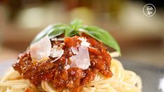 spaghetti with sauce and basil on top