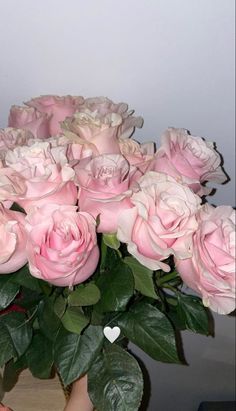 a vase filled with pink roses on top of a table