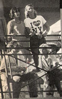 an old black and white photo of two women on a boat with other people in the background