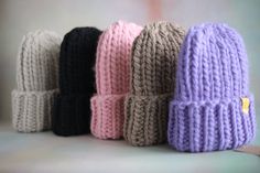 several knitted hats are lined up on a table