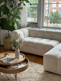 a living room filled with furniture and a large window overlooking a city street in the distance