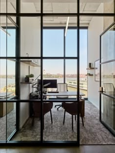 an office with large glass windows overlooking the city