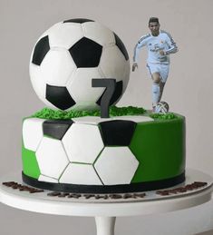 a cake with a soccer ball on top and a player figurine next to it