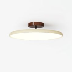 an overhead view of a circular light fixture on a white wall with a brown wooden trim