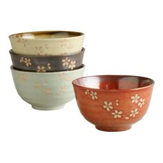 four bowls with flower designs on them sitting side by side