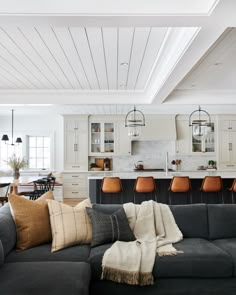 a living room filled with furniture and lots of pillows on top of a black couch