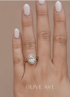 a woman's hand with a diamond ring on top of her finger and the words olive ave written below it