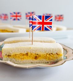 there is a sandwich with an union jack flag sticking out of it on a plate