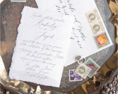 two envelopes and some stamps on a silver tray