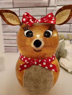 a close up of a figurine of a deer with a bow on it's head